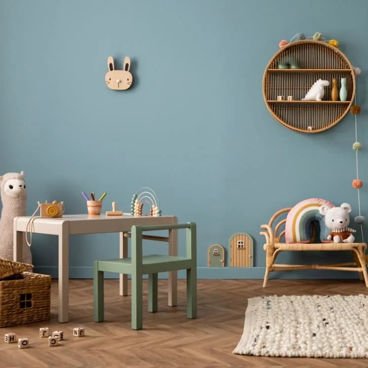 Children's room with a soft blue wall and wooden toys