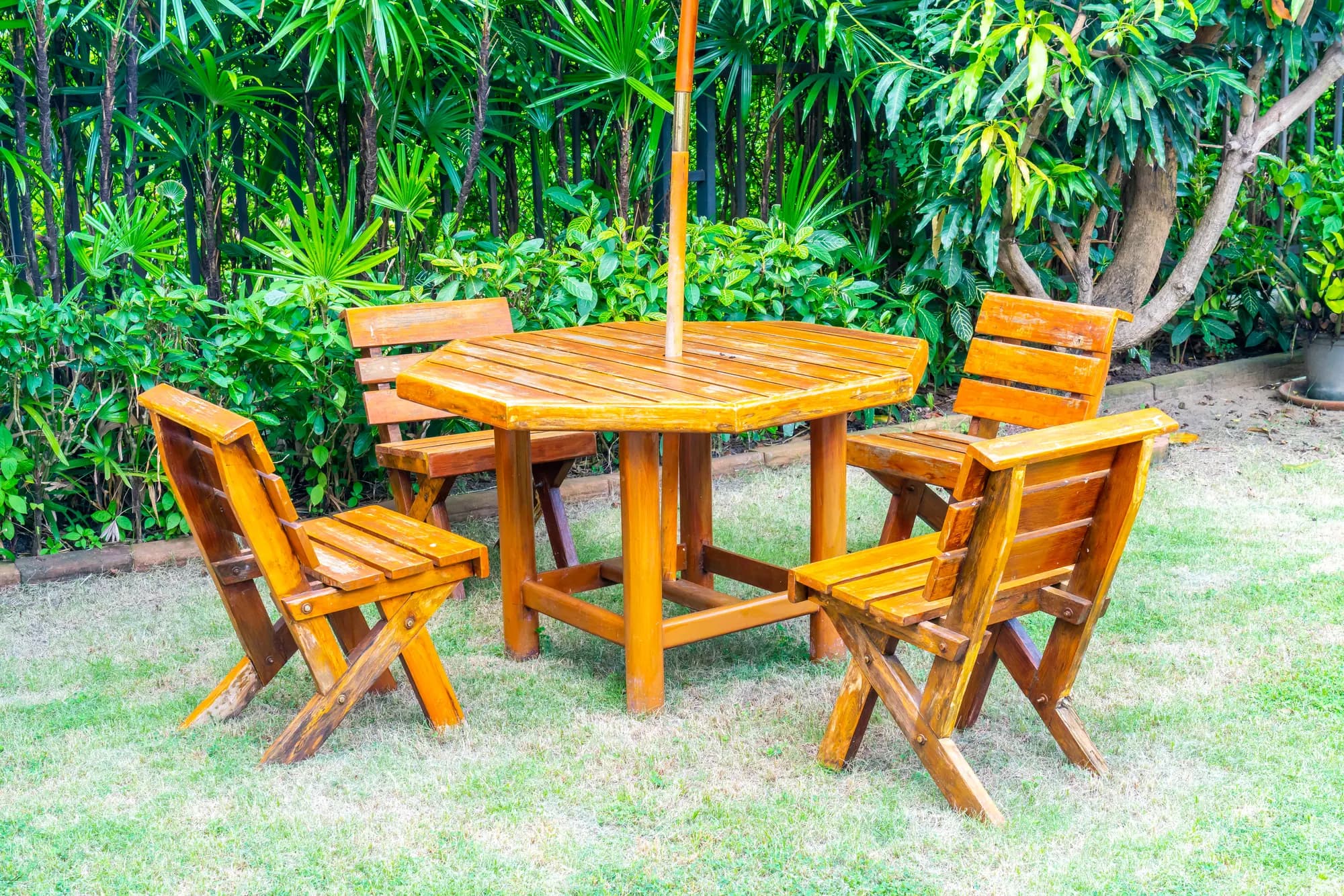 Varnished wooden garden table and chairs on a lawn